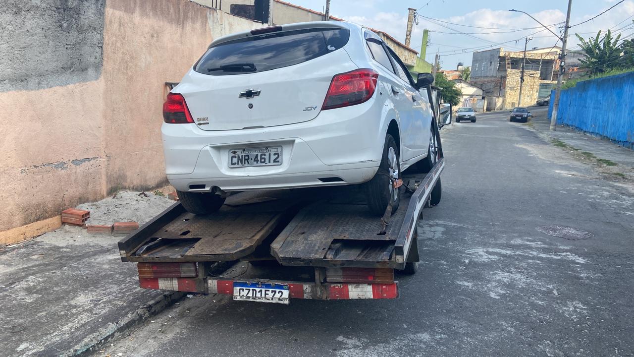 Veiculo branco sendo transportado por guincho